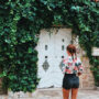 a person standing in front of a wall full of ivy