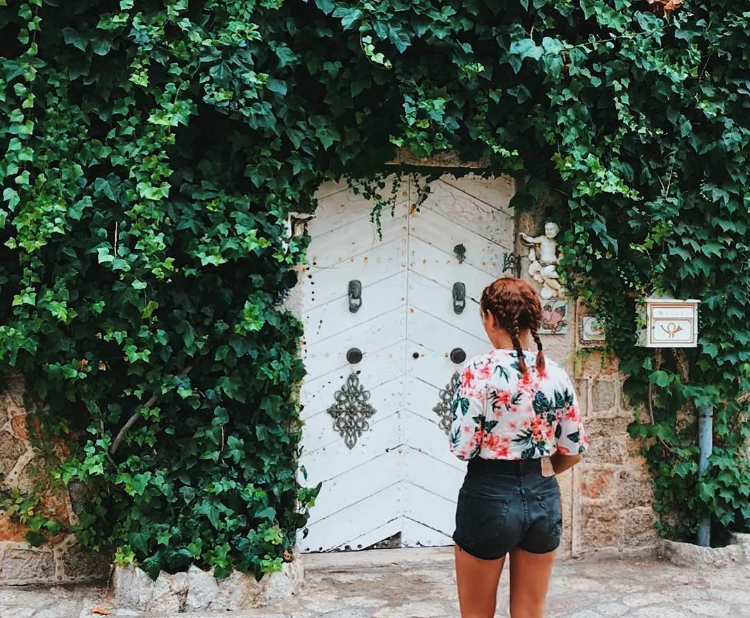 a person standing in front of a wall full of ivy